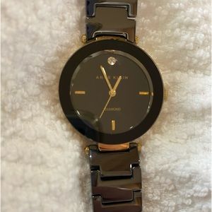 Anne Klein watch with diamond accent. Gold tone black dial ceramic band